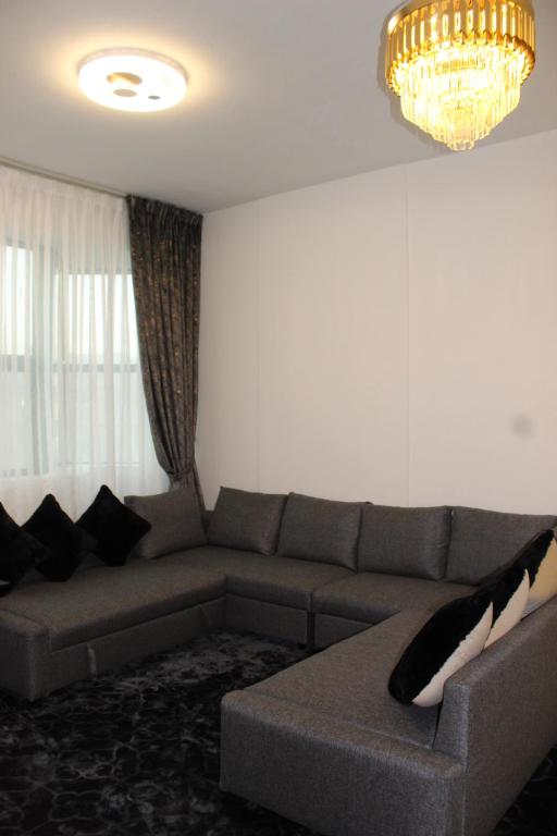 a living room with a couch and a chandelier at Ajman for families in Ajman 