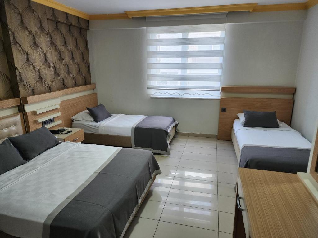 a room with two beds and a window at ANTALYA Konyaaltı Gündüz Otel in Antalya