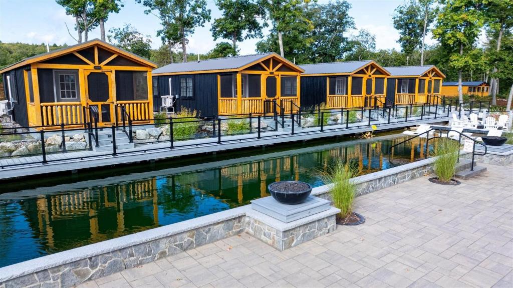 a row of yellow cabins with a pool of water at CARDINAL LIMIT 3 in North Sebago