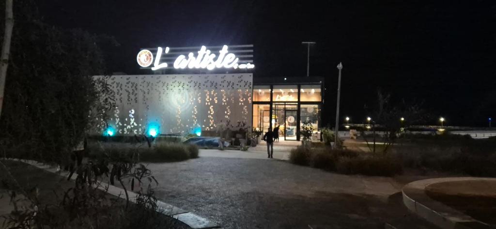 a person riding a bike in front of a store at night at Spacieux Appartement Selouane Nador in Selouane