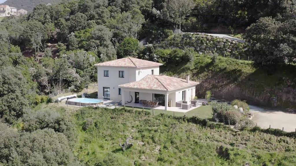 una vista aerea di una casa bianca su una collina di Villa pour 8 avec piscine a Compoli