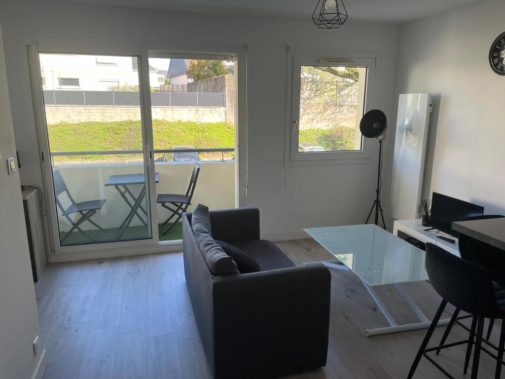 un salon avec un canapé et une table en verre dans l'établissement Appartement Vannes en résidence, à Vannes
