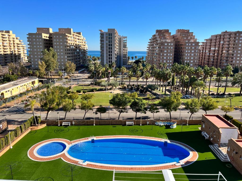a large swimming pool in a city with tall buildings at ACV - Torremar-2ª linea planta 3 sur 2 in El Borseral