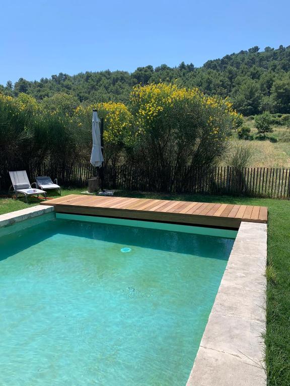 - une piscine dans une cour avec une terrasse en bois dans l'établissement Gite Sud Luberon, à Grambois