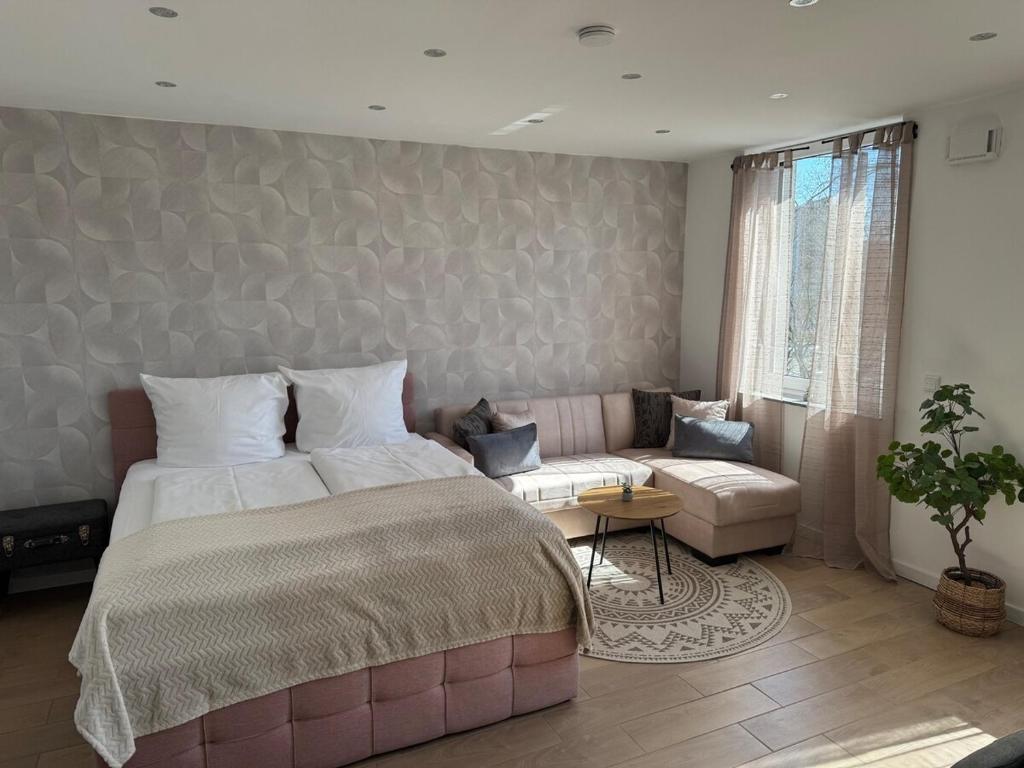 a bedroom with a large bed and a couch at Boutique Studio Apartment Lucca - Parkplatz - Bahnhof in Osnabrück