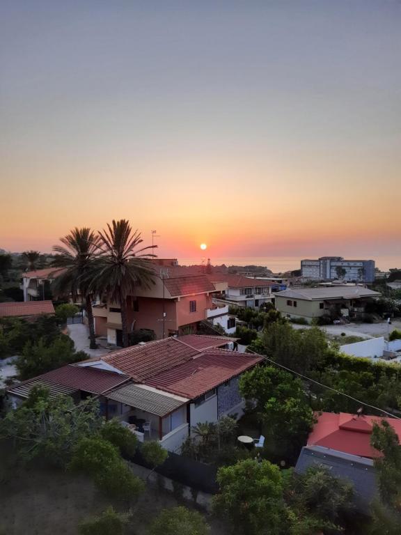 a sunset over a town with houses and palm trees at Villa Mirabelli in Tropea