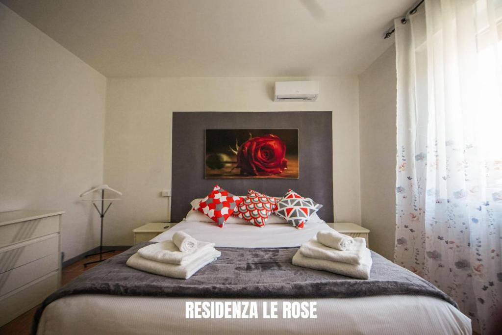 a bedroom with a bed with towels on it at Residenza Le Rose Apartament FREE BIKE in Peschiera del Garda