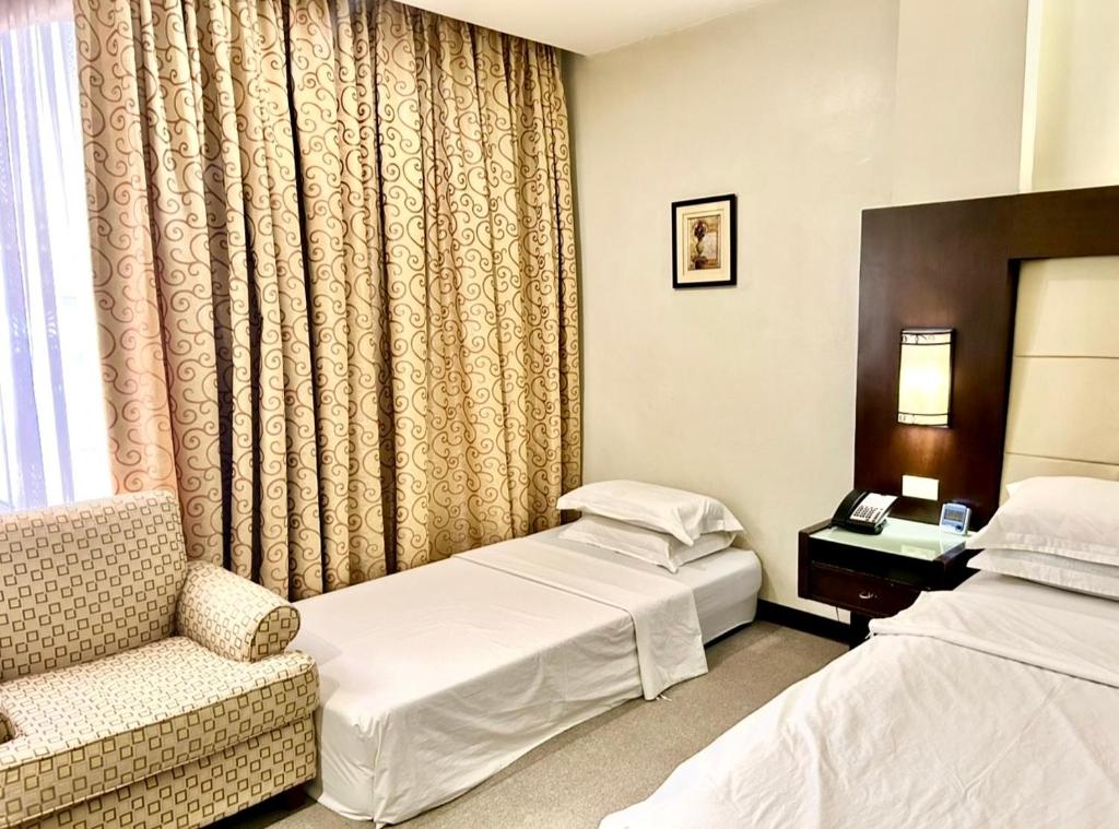 Postel nebo postele na pokoji v ubytování Circle Inn Hotel and Suites Bacolod