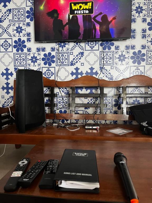 a desk with a computer and a tv on a wall at Villa Talisay - Beach house in Samal