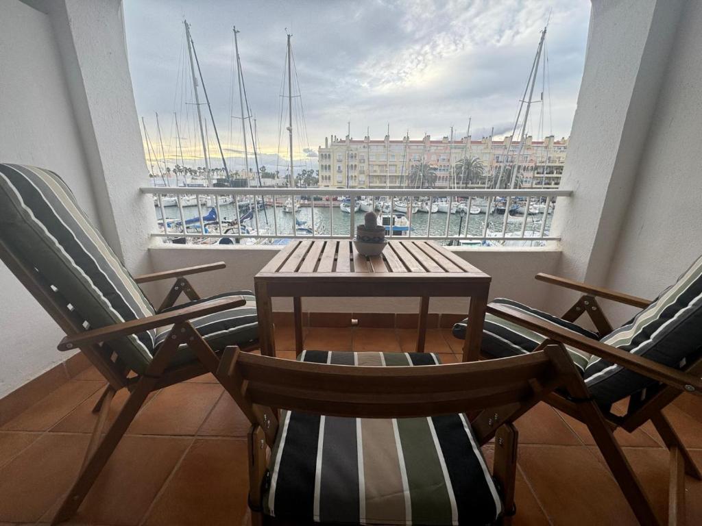 a table and chairs on a balcony with a view of a harbor at Cozy Sunset in Almerimar