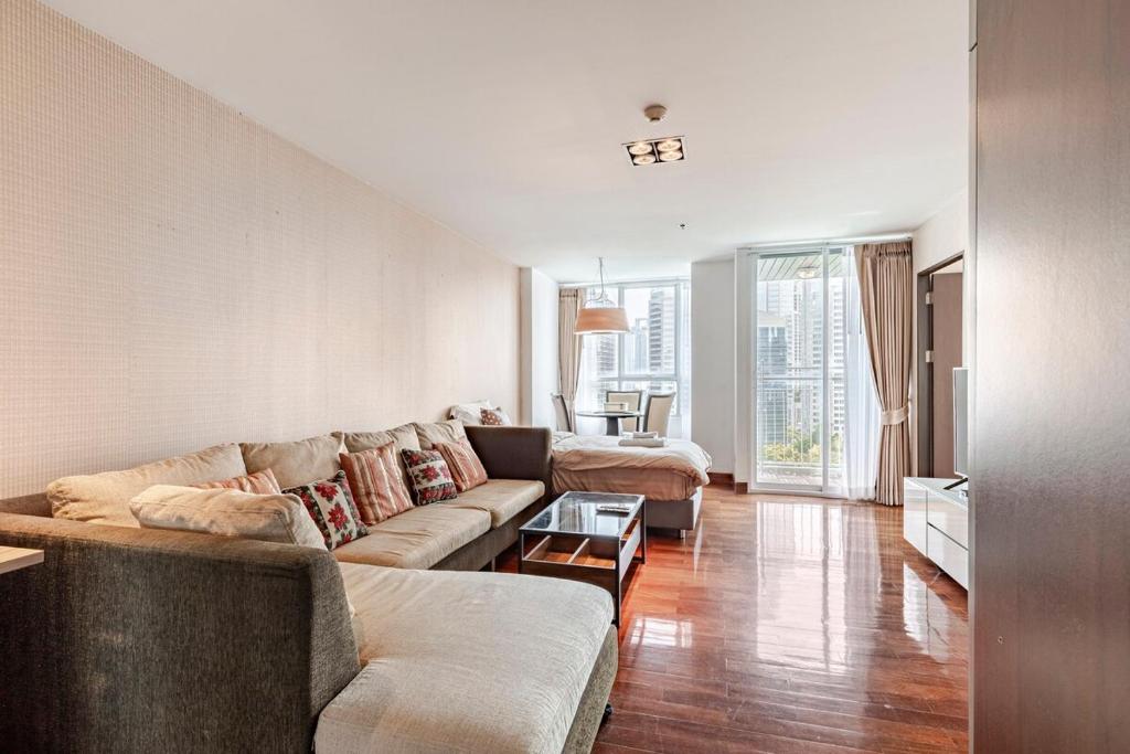 a living room with a couch and a table at 2 BR in Downtown BTS Chitlom BKK in Bangkok