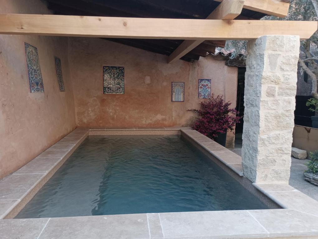 einen Pool im Hinterhof mit Holzdach in der Unterkunft Chambre d'hôte Les Oulies Bédoin in Bédoin