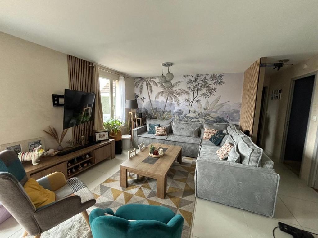 un salon avec deux canapés et une télévision dans l'établissement Maison proche du circuit des 24h du Mans, à Ruaudin