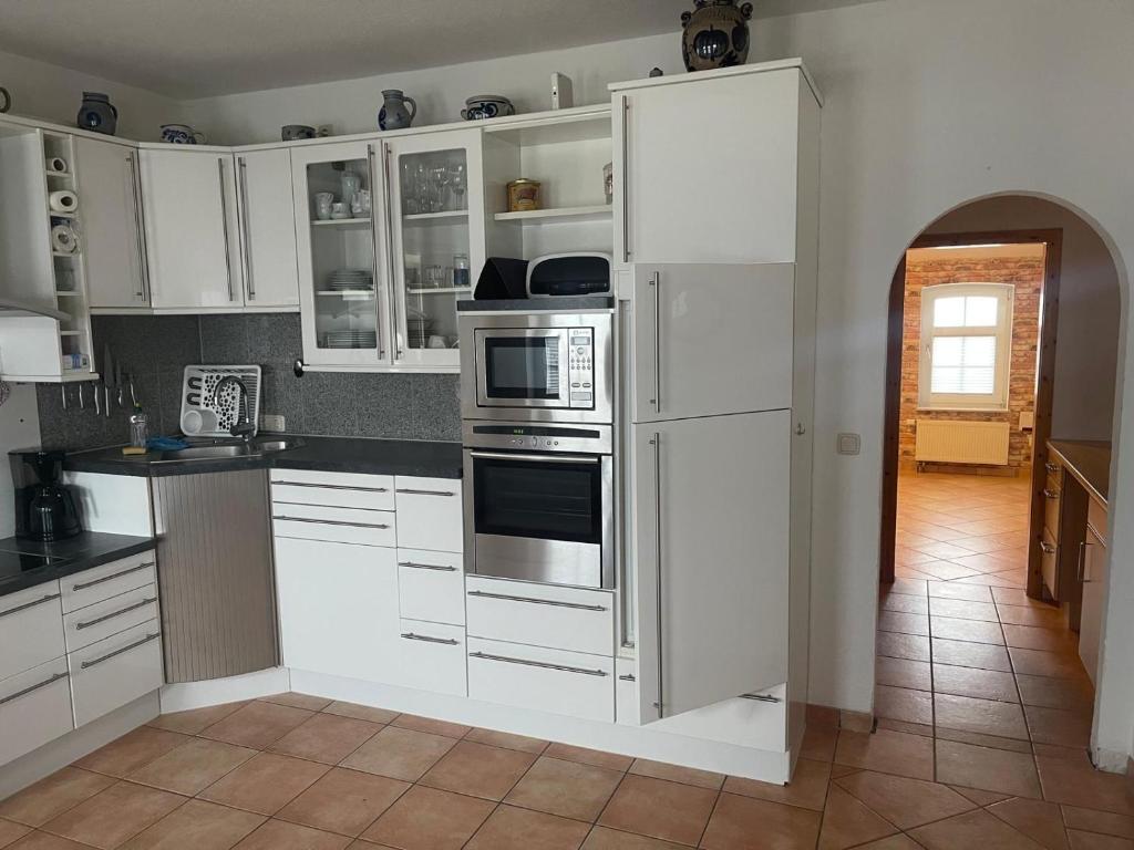 a white kitchen with white cabinets and appliances at Boardinghouse Südbrookmerland in Südbrookmerland
