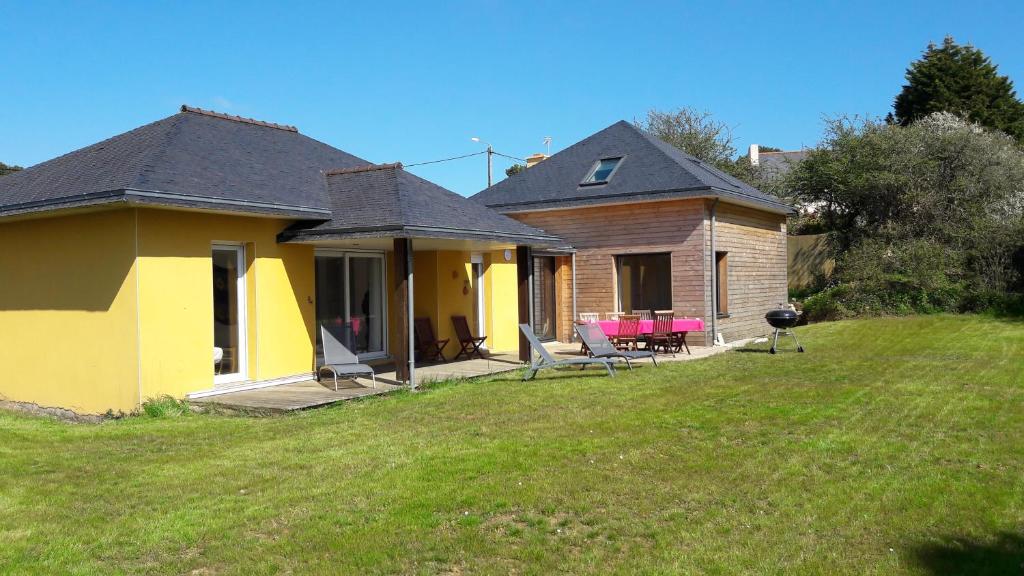 une maison jaune avec une terrasse couverte et une cour dans l'établissement Grande maison sur propriété près de la plage de Morgat, à Crozon