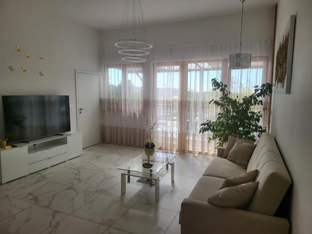 a living room with a couch and a flat screen tv at Apartma Lucija in Lucija