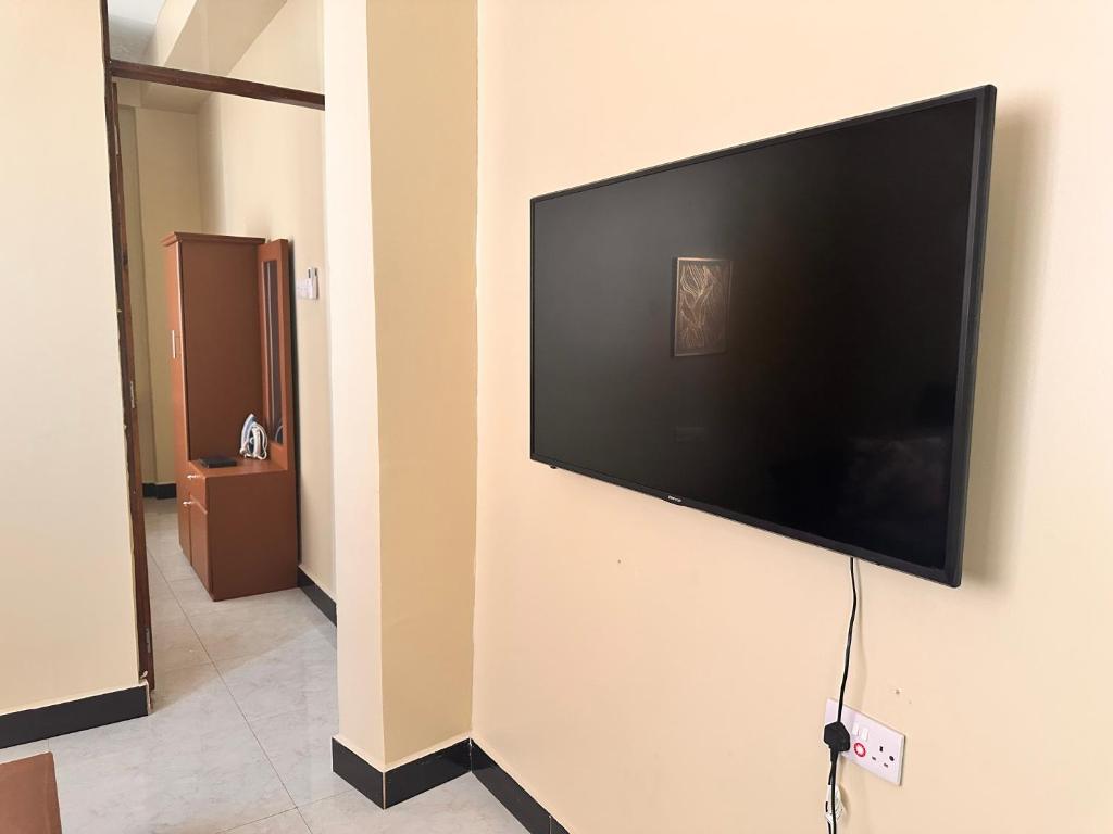 a flat screen tv hanging on a wall at Soul naz homes in Dar es Salaam