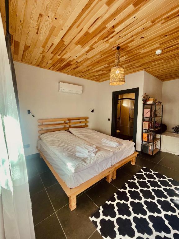 Schlafzimmer mit einem Bett mit Holzdecke in der Unterkunft Casa Natura Adrasan in Adrasan