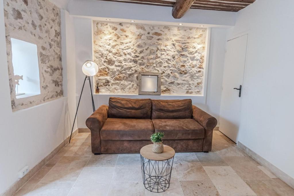 un salon avec un canapé marron et une table dans l'établissement Superbe 2 Pièces - Viel Antibes, à Antibes
