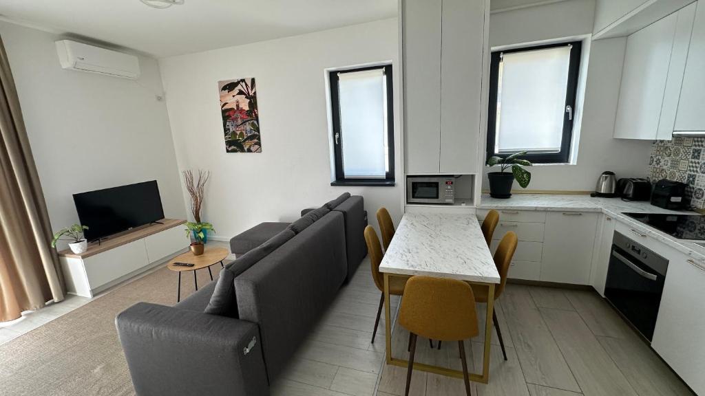 a living room with a couch and a table with chairs at Citadel 2 - Powered By NEO - Free Parking in Timişoara