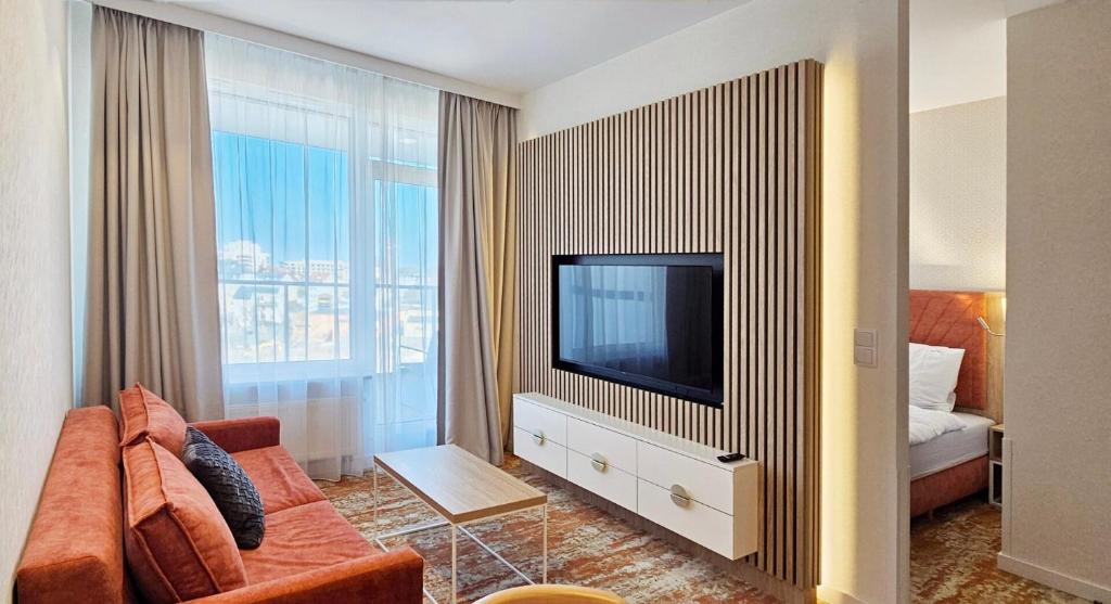 un salon avec un canapé et une télévision dans l'établissement HolidayHomePL Bel Mare F505 z sypialnią i balkonem, à Międzyzdroje