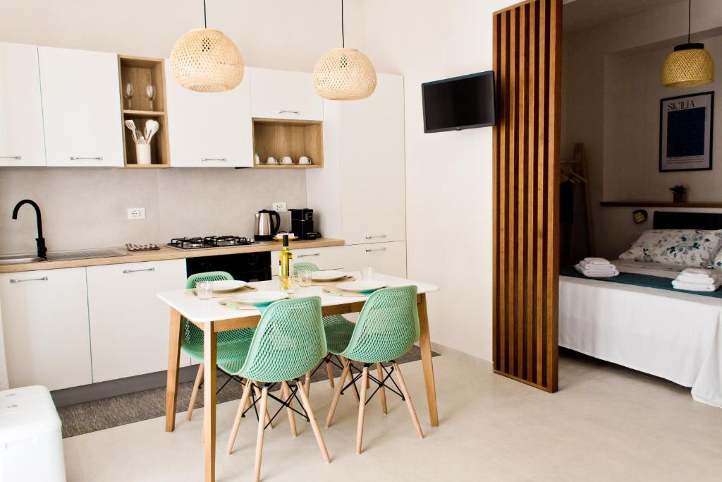 a kitchen with a table and chairs in a room at Verdeacqua Home in Castellammare del Golfo