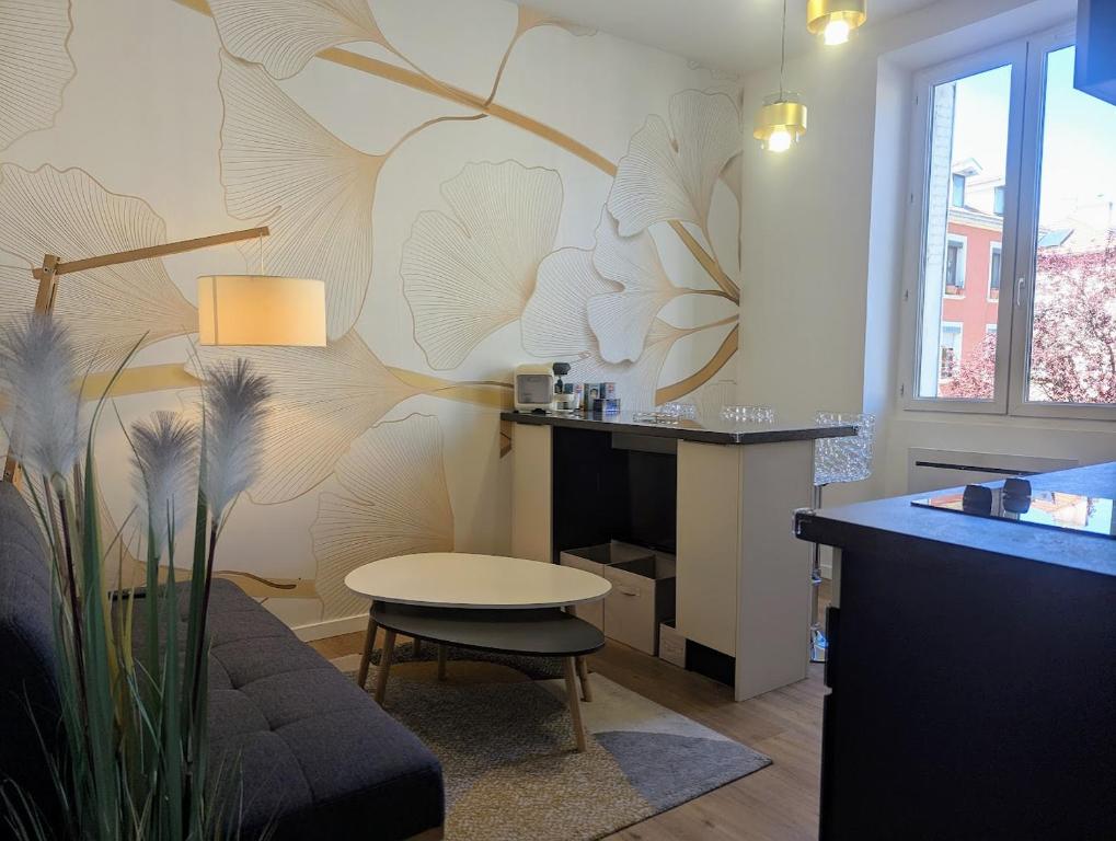 un salon avec une table, un canapé et un mur dans l'établissement Calme sérénité et lumière, à Grenoble