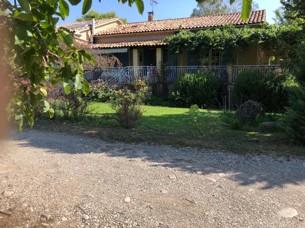 une maison avec une clôture devant une cour dans l'établissement La maison de Mimi, à Ribiers