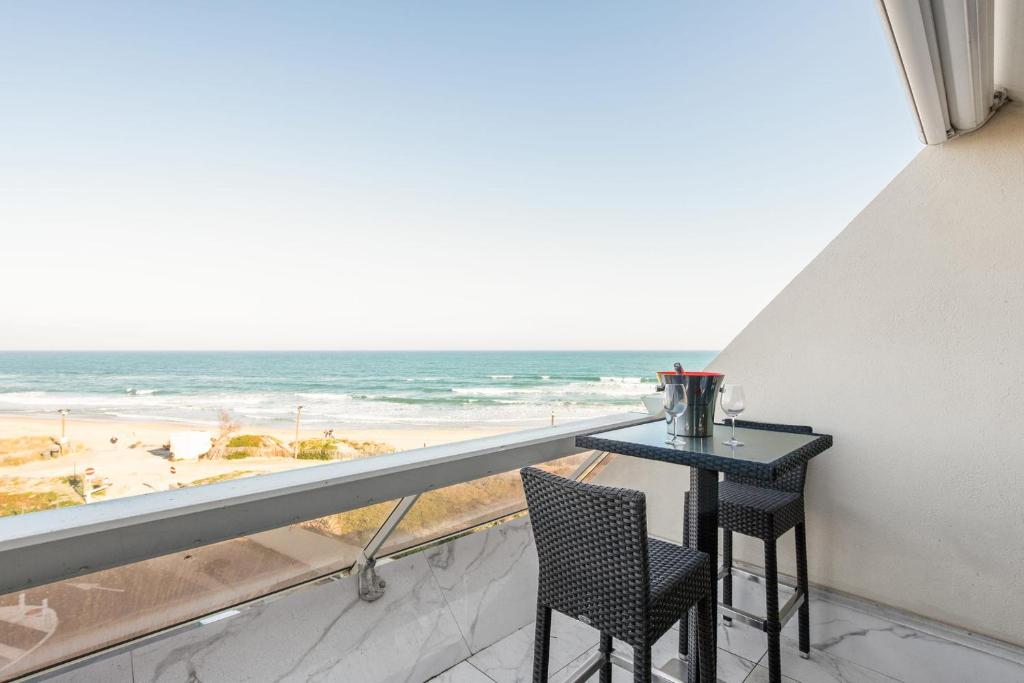 un balcon avec une table et des chaises et une vue sur la plage dans l'établissement Sea Life Heliopolis, au Cap d'Agde