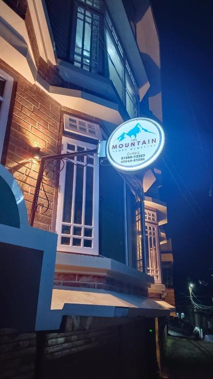 a sign on the side of a building at The Mountain Range Homestay in Darjeeling