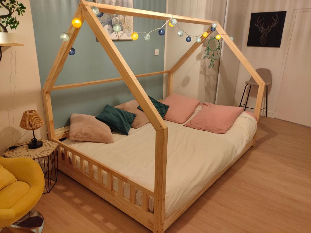 a wooden bed with pillows on it in a room at Au coeur de la vieille ville, Chambre privée indépendante in Sommières