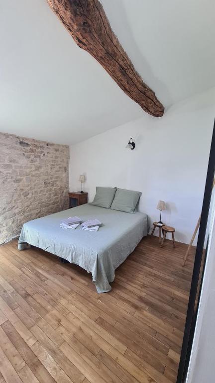 une chambre avec un lit et un mur de briques dans l'établissement La petite maison 1766, à Valence