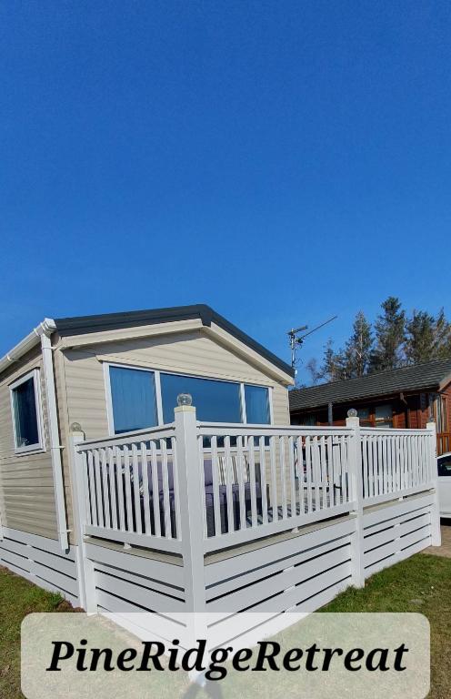 a white fence in front of a house at Pine Ridge Retreat With FREE GOLF and Air Conditioning in Morpeth