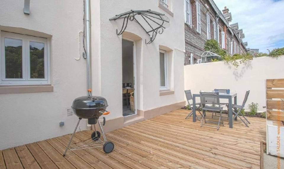 - un barbecue sur une terrasse avec une table et des chaises dans l'établissement La cabane de plage, à Étretat
