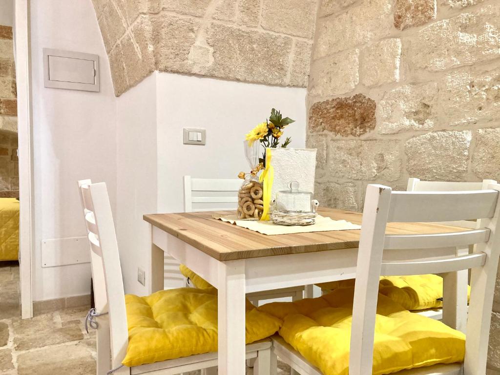 a table and chairs with yellow cushions in a room at Antica Pietra in Polignano a Mare