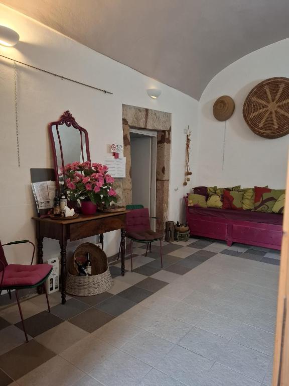 a room with a couch and a table and a mirror at Aghinas in Bosa