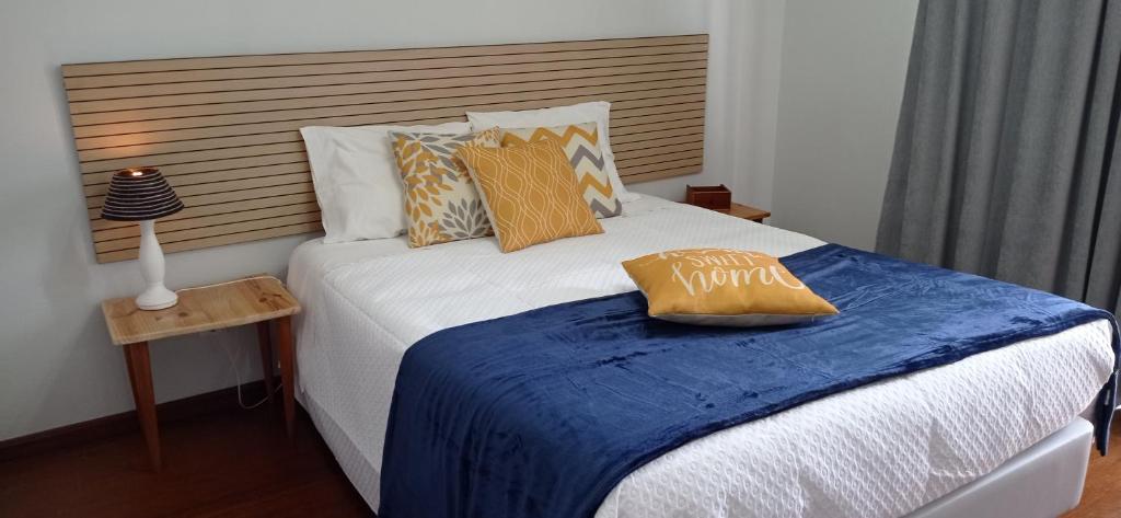 a bedroom with a bed with a blue blanket at Pipo People House in Óbidos