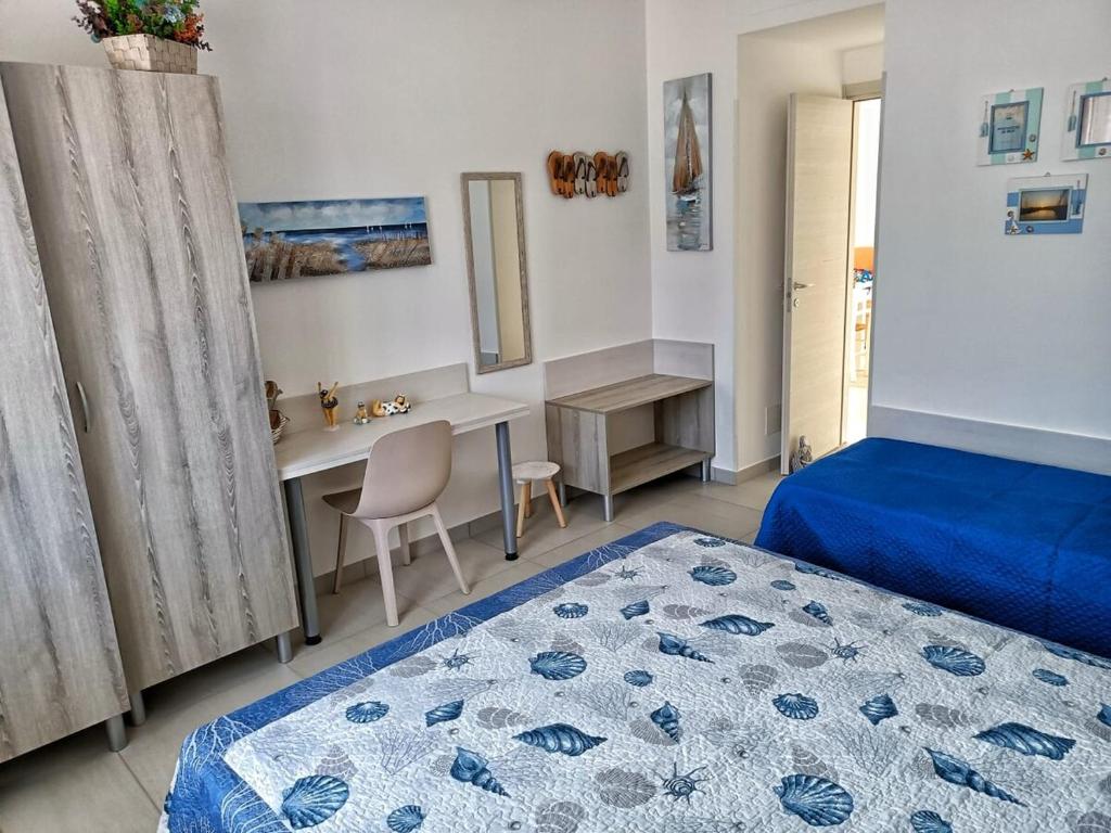 a bedroom with a bed and a desk and a table at Appartamento Mimosa in Boissano