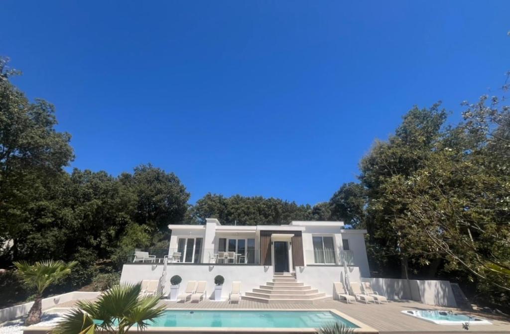 une maison blanche avec une piscine et des arbres dans l'établissement Beautiful 4 bedroom villa with pool, jacuzzi, à Biot