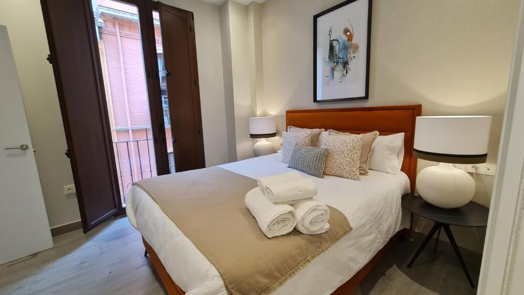 ein Schlafzimmer mit einem Bett mit Handtüchern darauf in der Unterkunft Suspiro 201 Elegant Suite in Granada