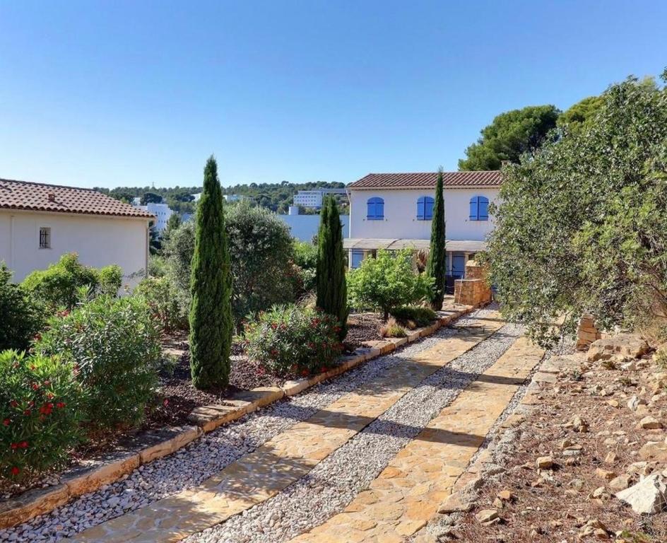un jardin avec des arbres et une maison dans l'établissement vent du cap, à La Ciotat