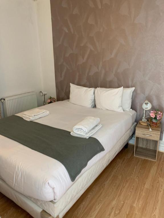 a bedroom with a large bed with white pillows at KARIBU chic in Bezons