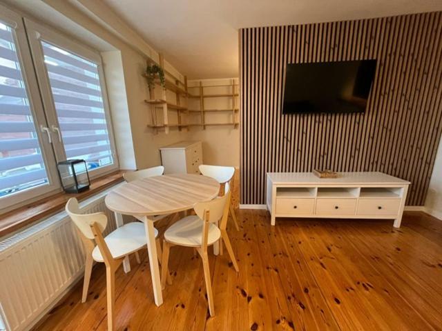 a dining room with a table and chairs and a tv at Kwatery u Szymka in Jastarnia