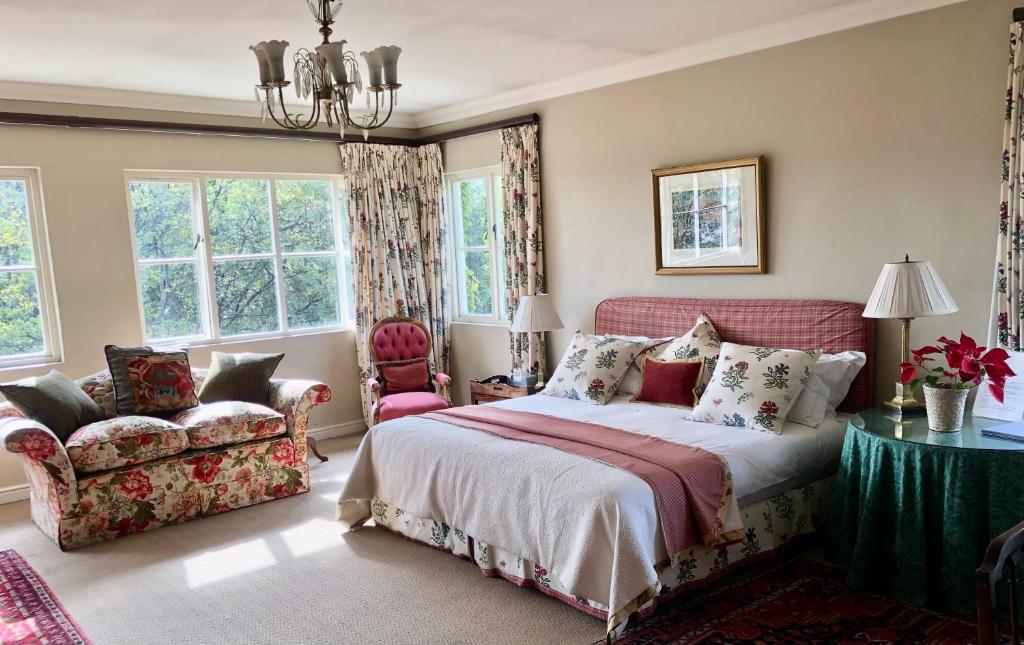 Un dormitorio con una cama y una mesa y sillas. en Grace on Argyle, Executive Suite in Sandton, en Johannesburgo