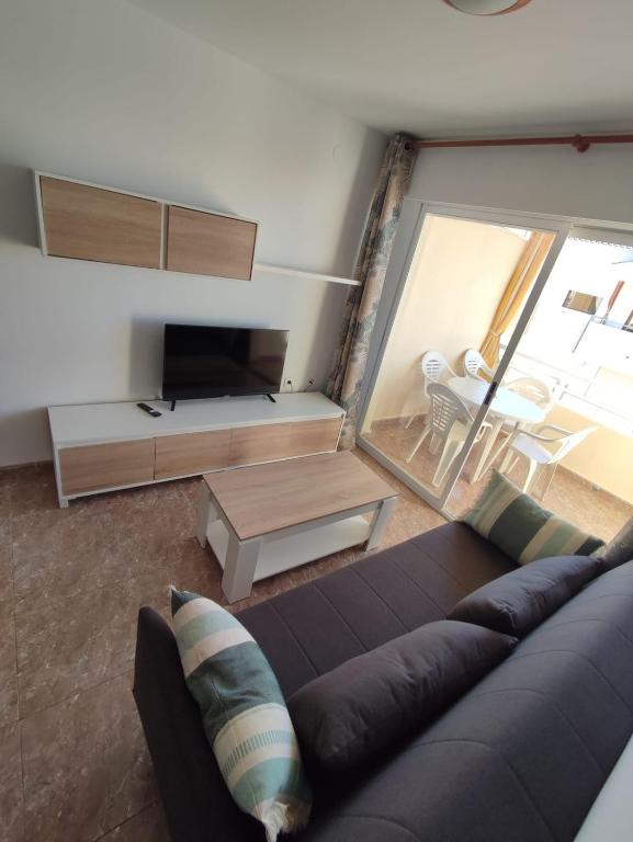a living room with a couch and a tv at Relax on Miramar Beach in Miramar
