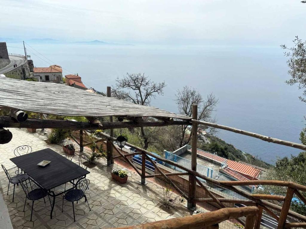 a patio with a table and chairs and the ocean at Ambra Holiday House in Furore
