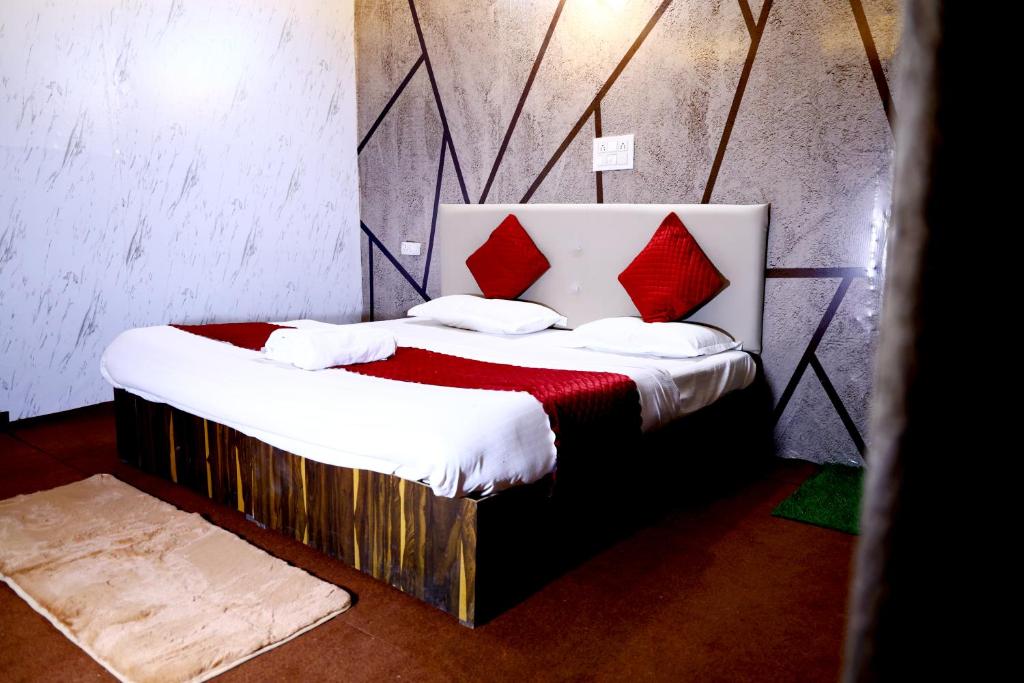 a bedroom with a large bed with red pillows at The Escapee Resort in Mussoorie