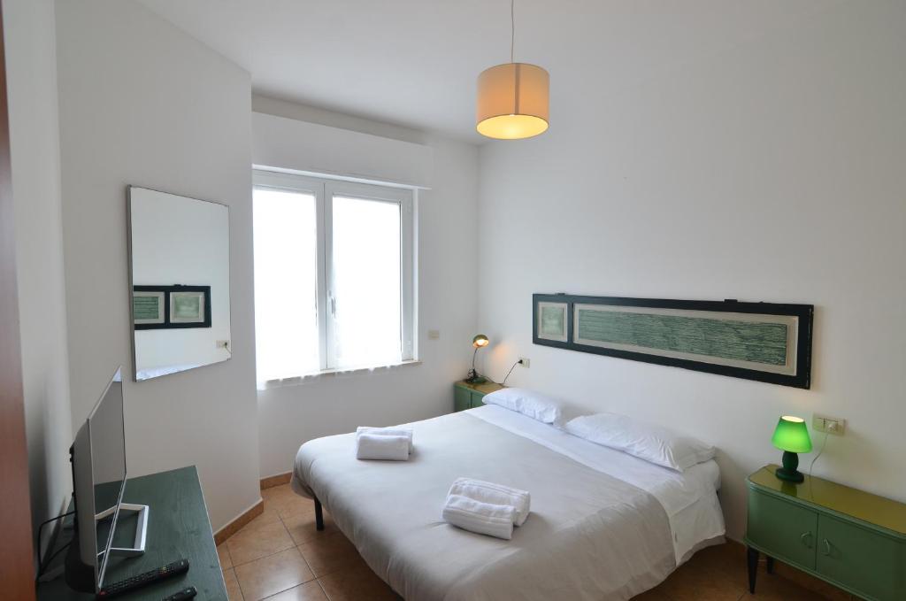 une chambre blanche avec un lit et une télévision dans l'établissement Assisi - Angelic Apartments, à Santa Maria degli Angeli