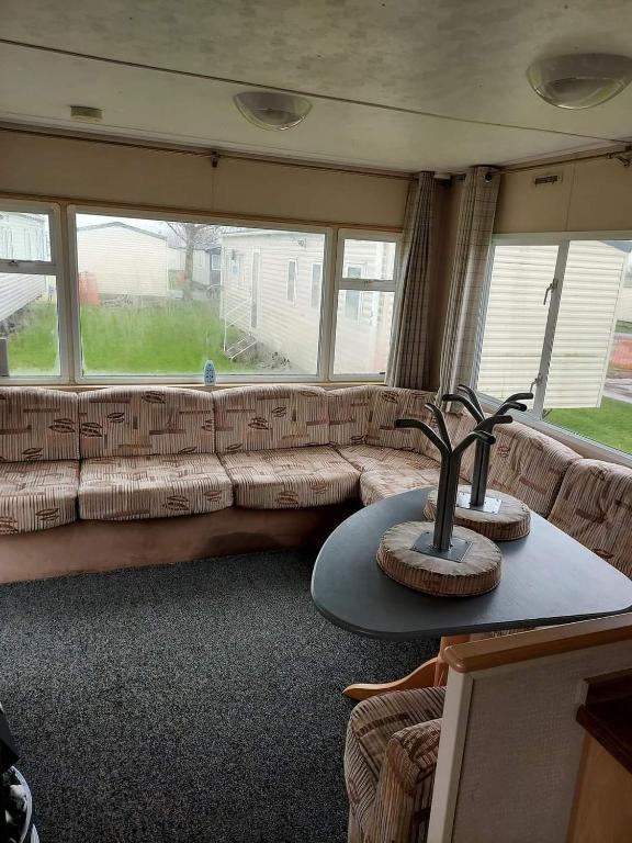 a living room with a couch and a large window at Caravan getaway sand le mere tunstall in Hull