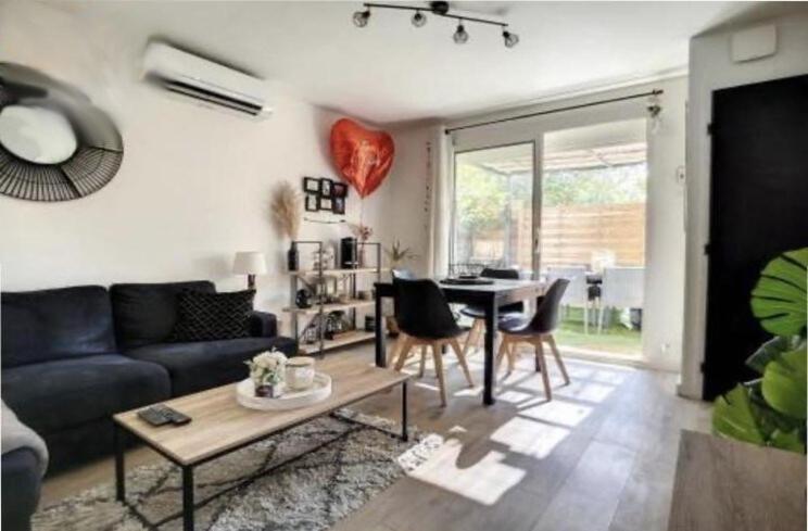 un salon avec un canapé et une table dans l'établissement Joli appartement climatisé avec extérieur, à Rognac